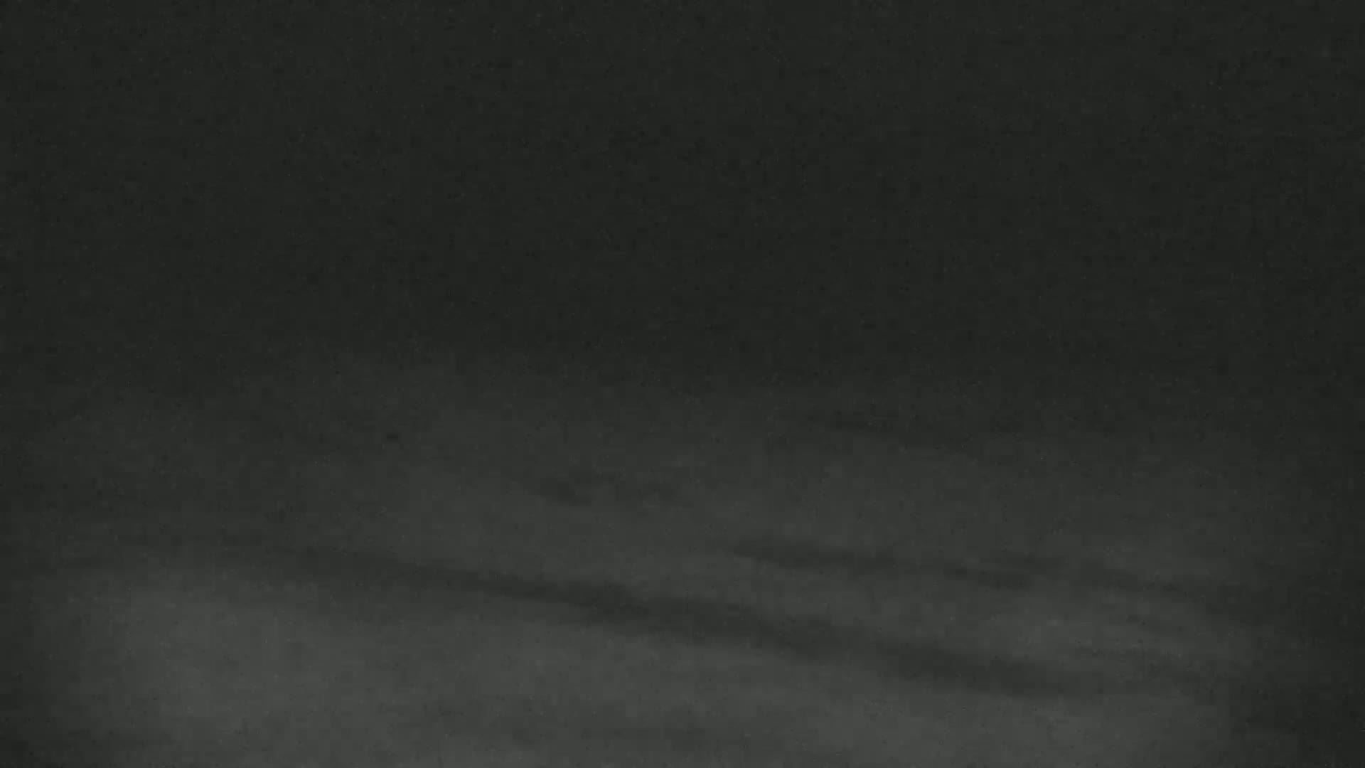 A dark, blurry image shows a mostly featureless, possibly snowy or foggy landscape at night.