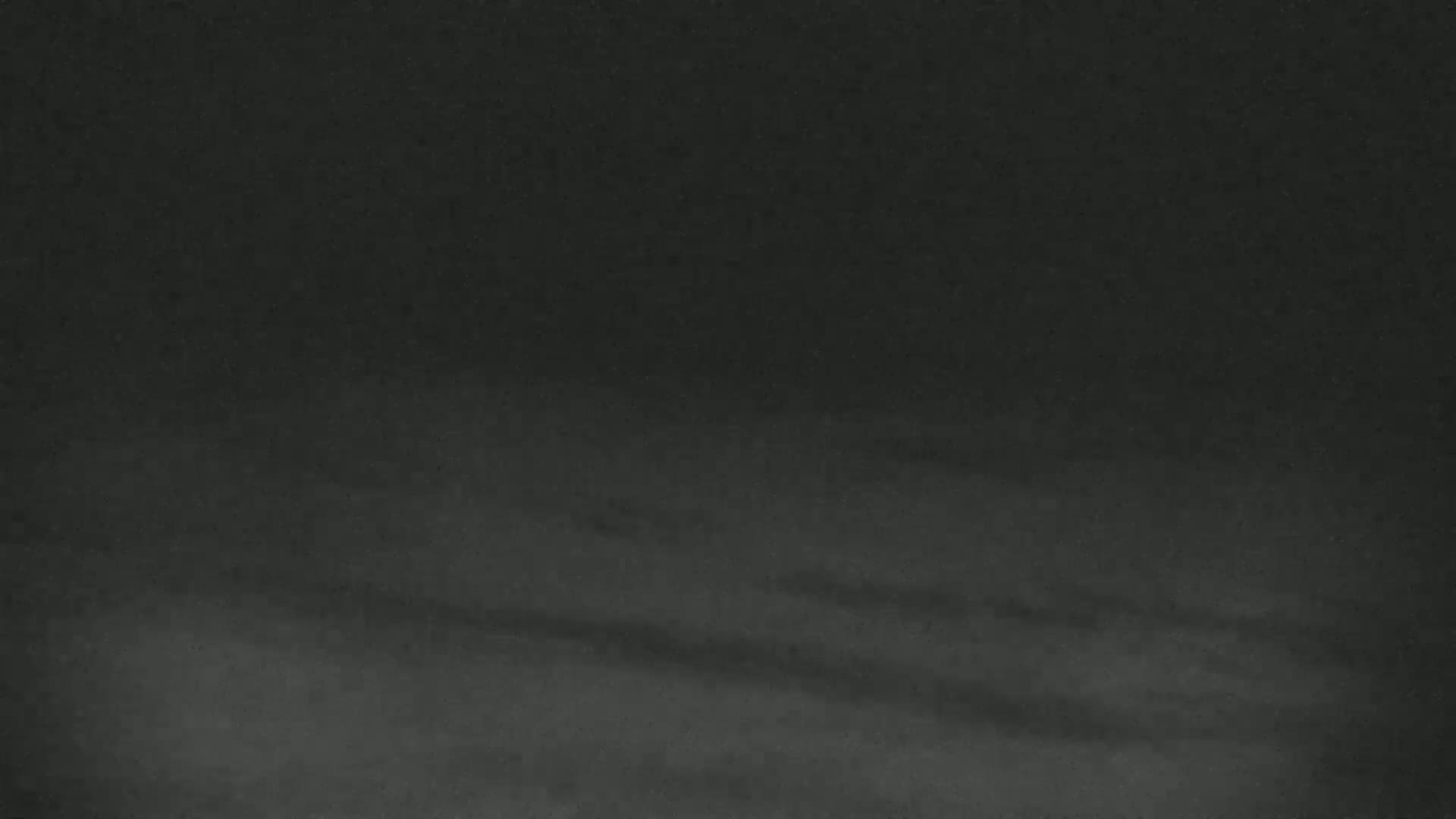 A dark, blurry image shows a mostly uniform gray-black surface with subtle horizontal shading.
