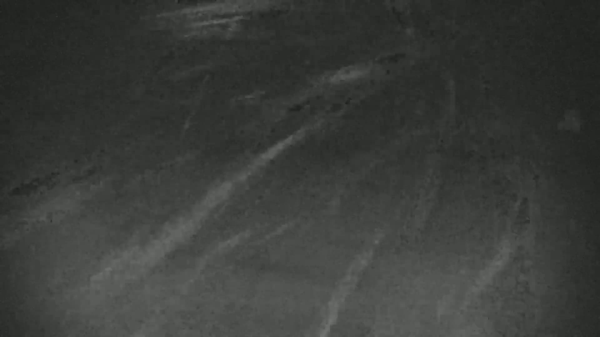 A dark gray surface shows streaks of lighter gray, resembling a textured background.