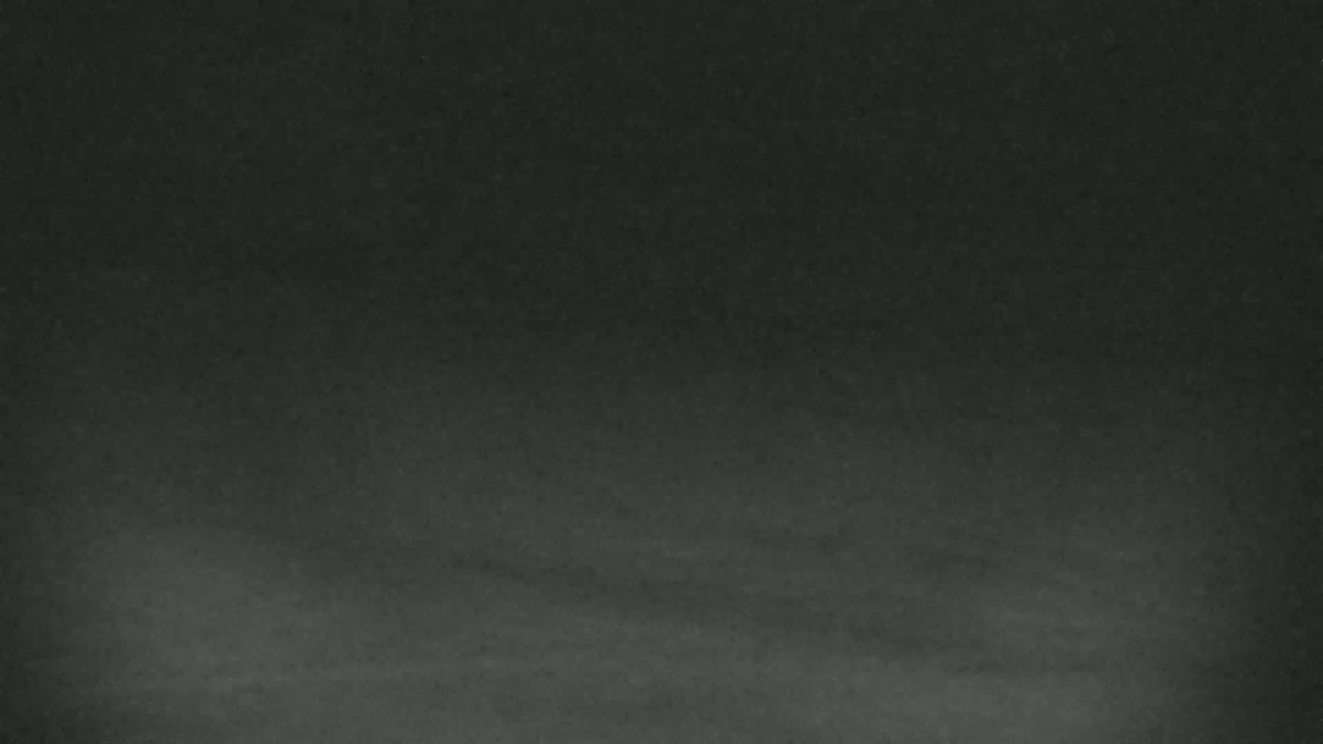 The image shows a dark gray, textured surface with subtle shading variations.