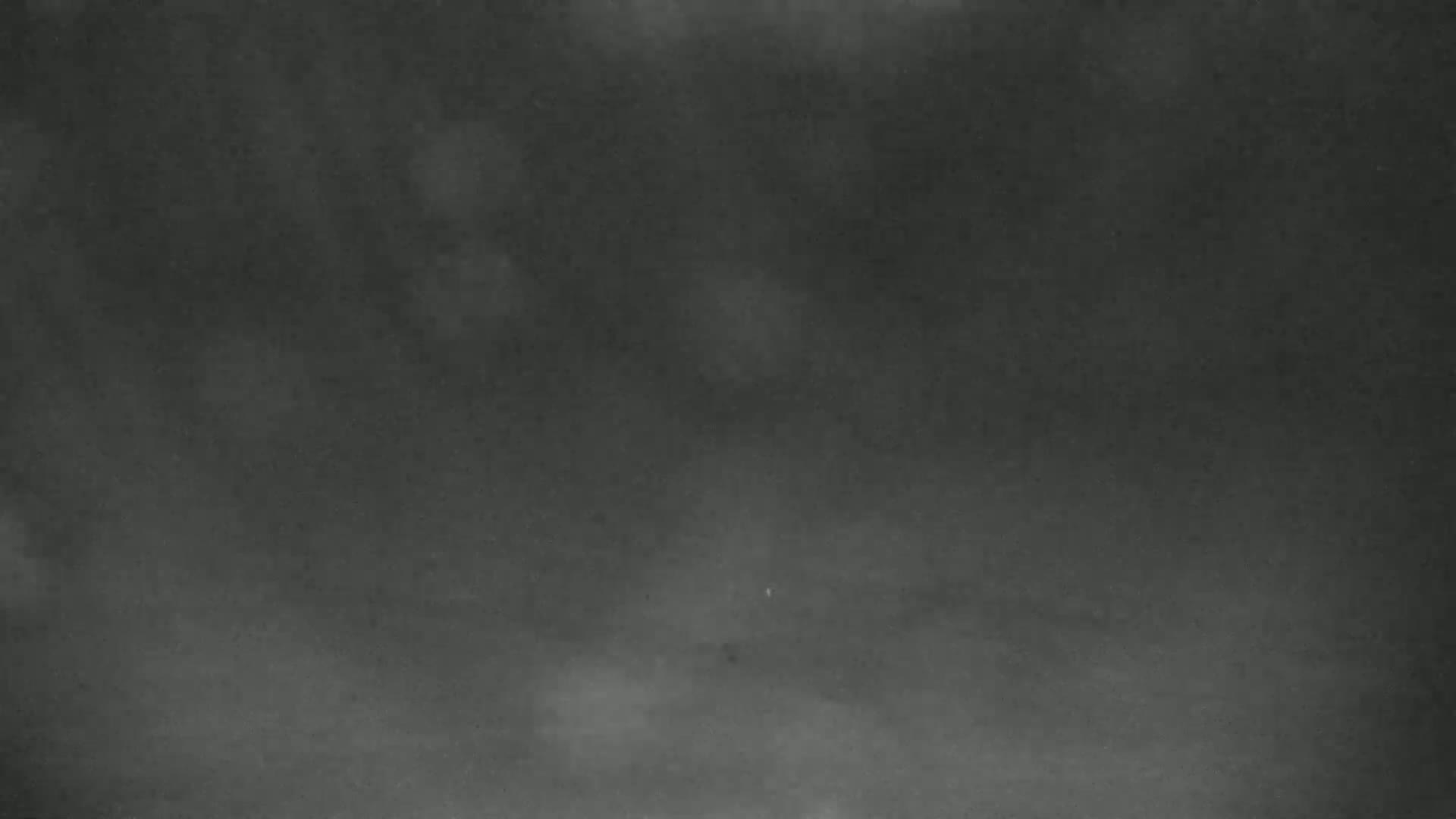 A dark, blurry image shows a foggy or hazy scene, possibly at night.