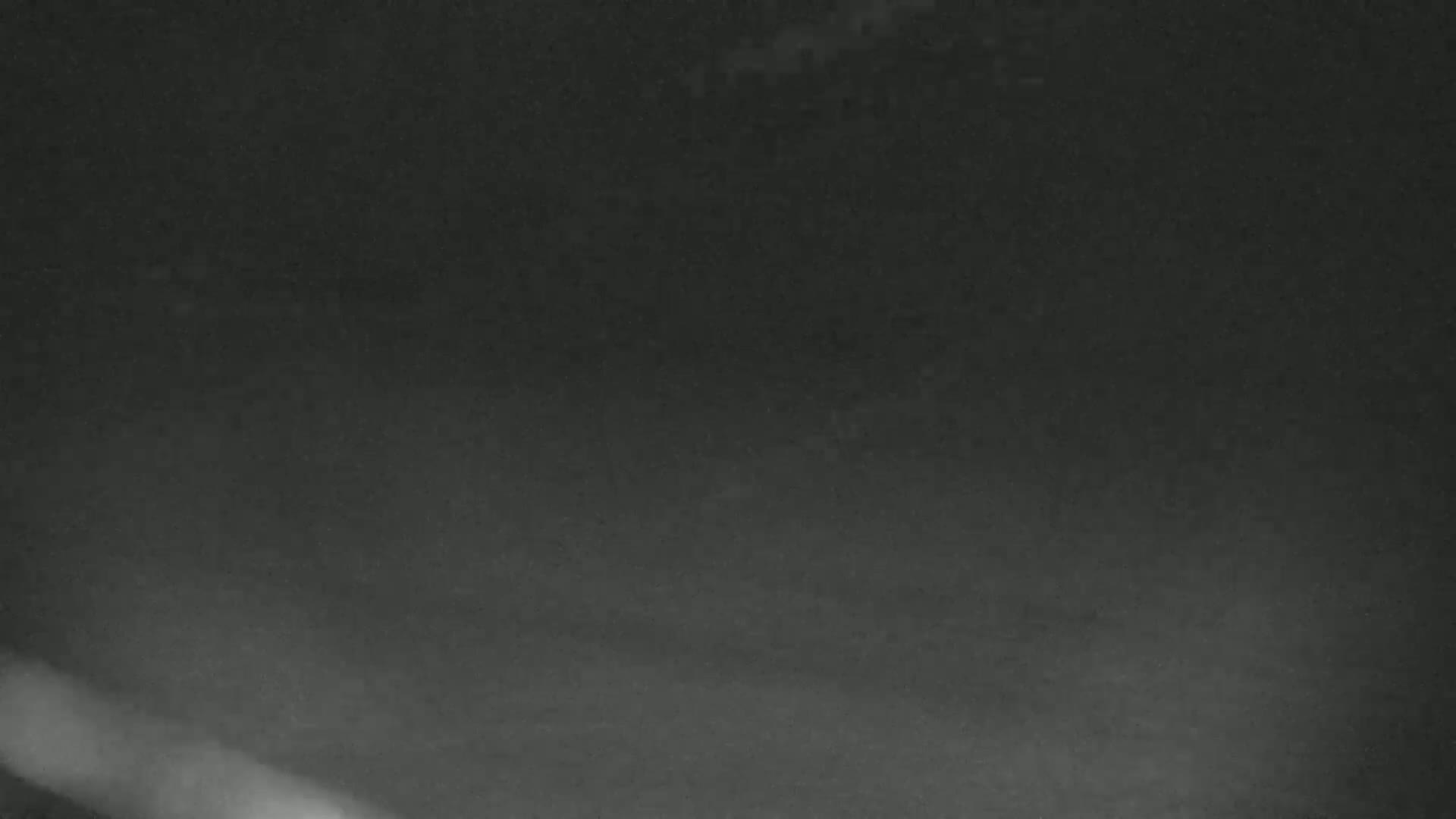 A dark, blurry image shows a mostly gray and black scene with a faint, brighter area at the bottom.