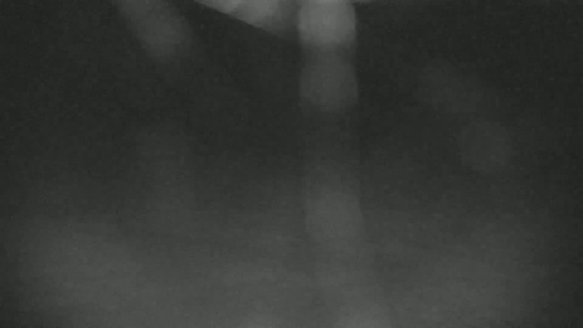 A dark, blurry image shows indistinct shapes and light areas against a mostly dark gray background.