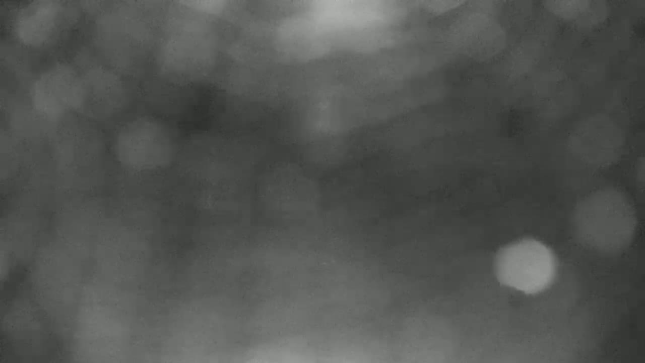 A dark, blurry image shows a hazy or foggy nighttime scene.