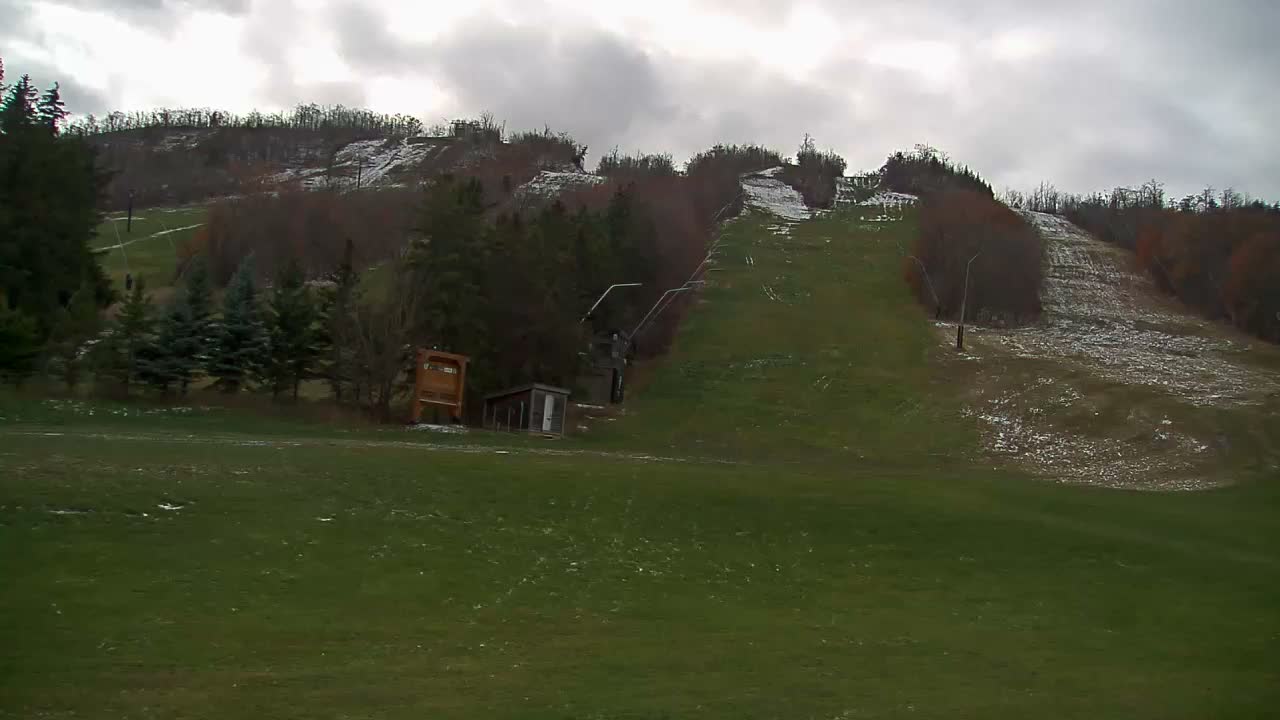 A blurry, dark grayscale image shows a bright light source in the upper left corner with faint, indistinct shapes suggesting an outdoor nighttime scene obscured by heavy fog or haze.