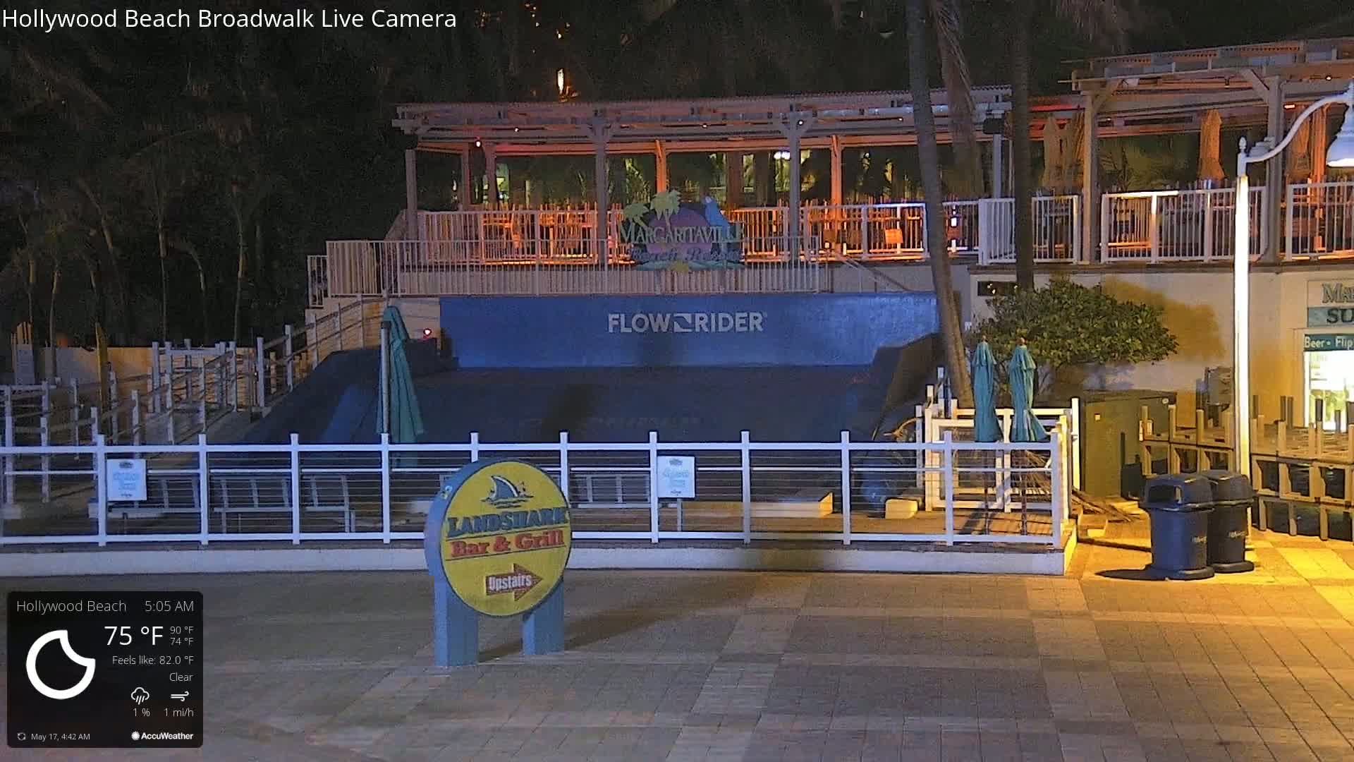 At night, under clear skies, a FlowRider surf simulator sits outside a bar and grill, adjacent to a Margaritaville restaurant.