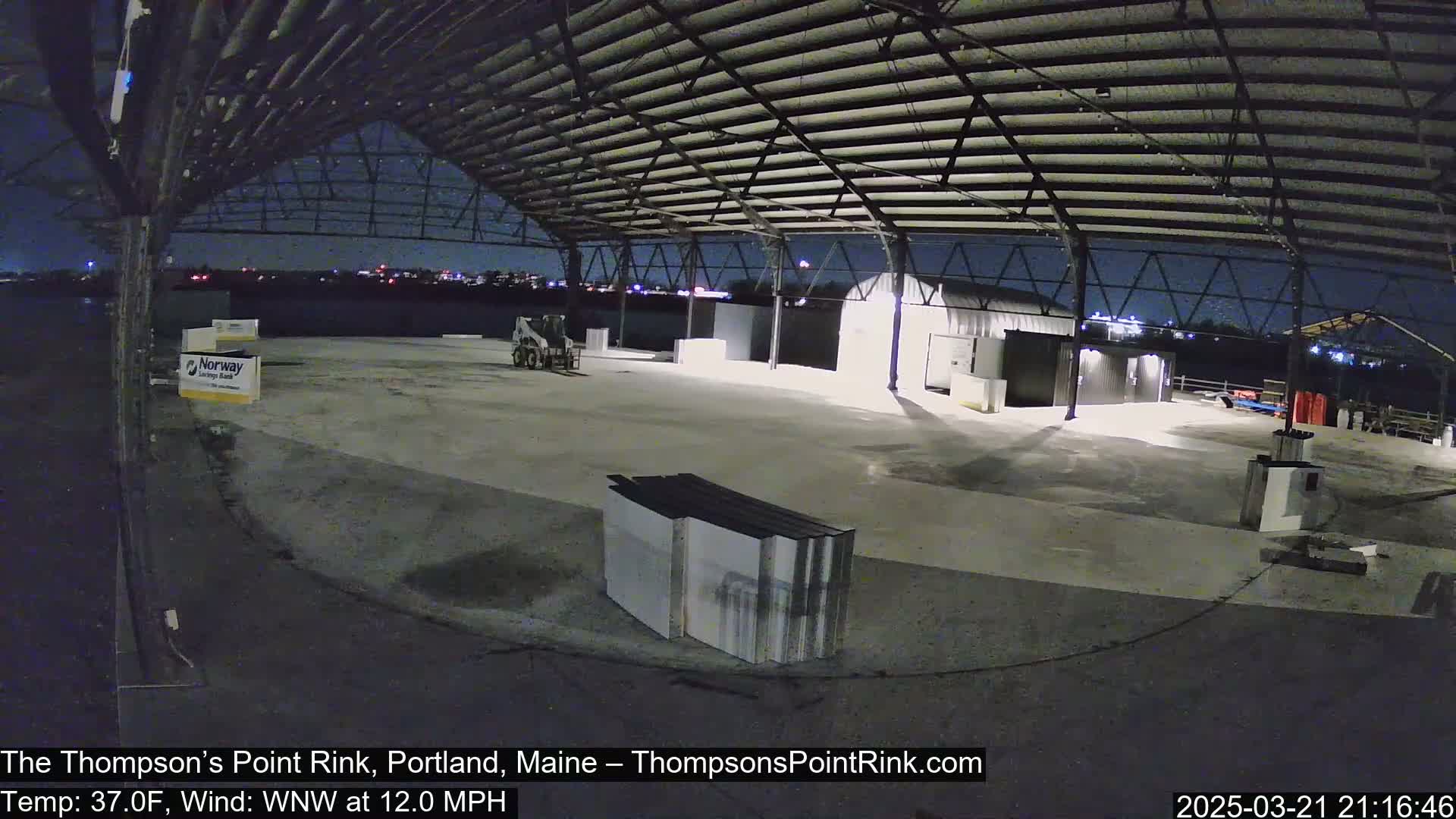 A large, empty, open-air structure under a nighttime sky with a slight wind.