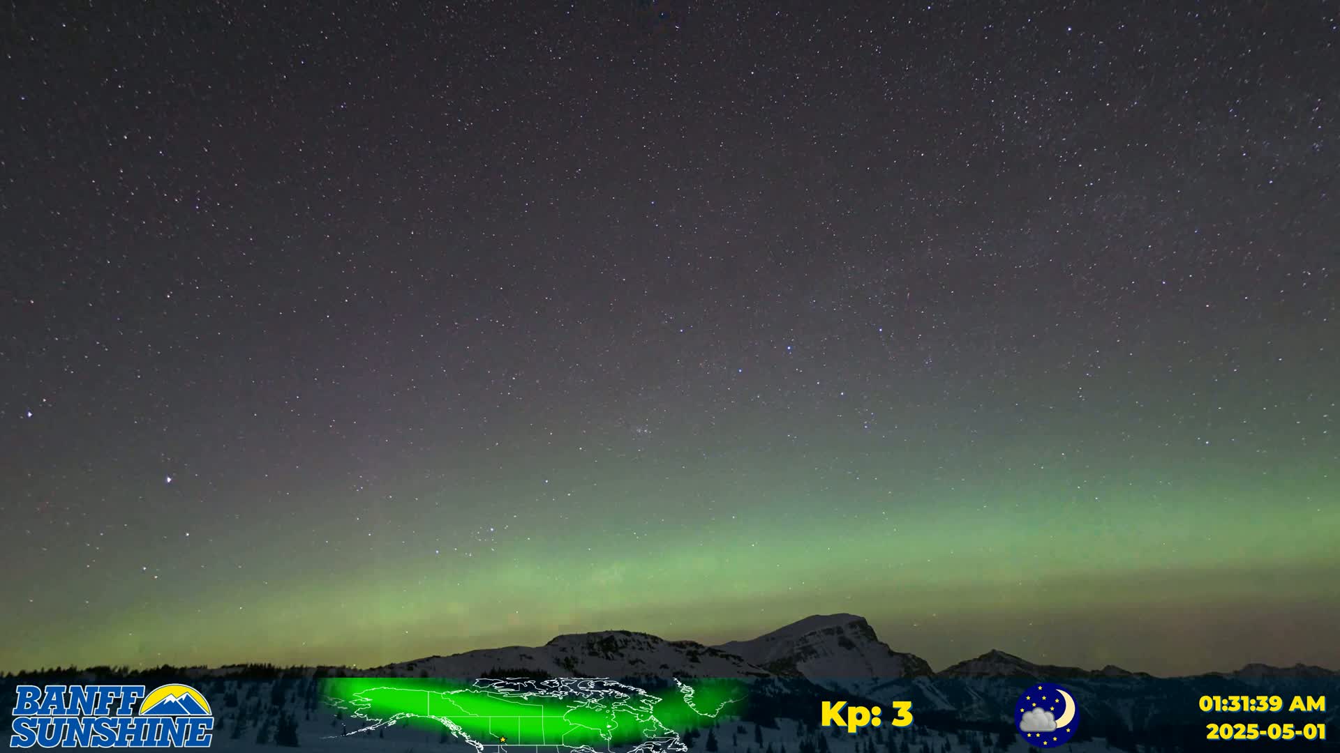 A vibrant green aurora borealis illuminates a night sky filled with stars above a snow-covered mountain range.