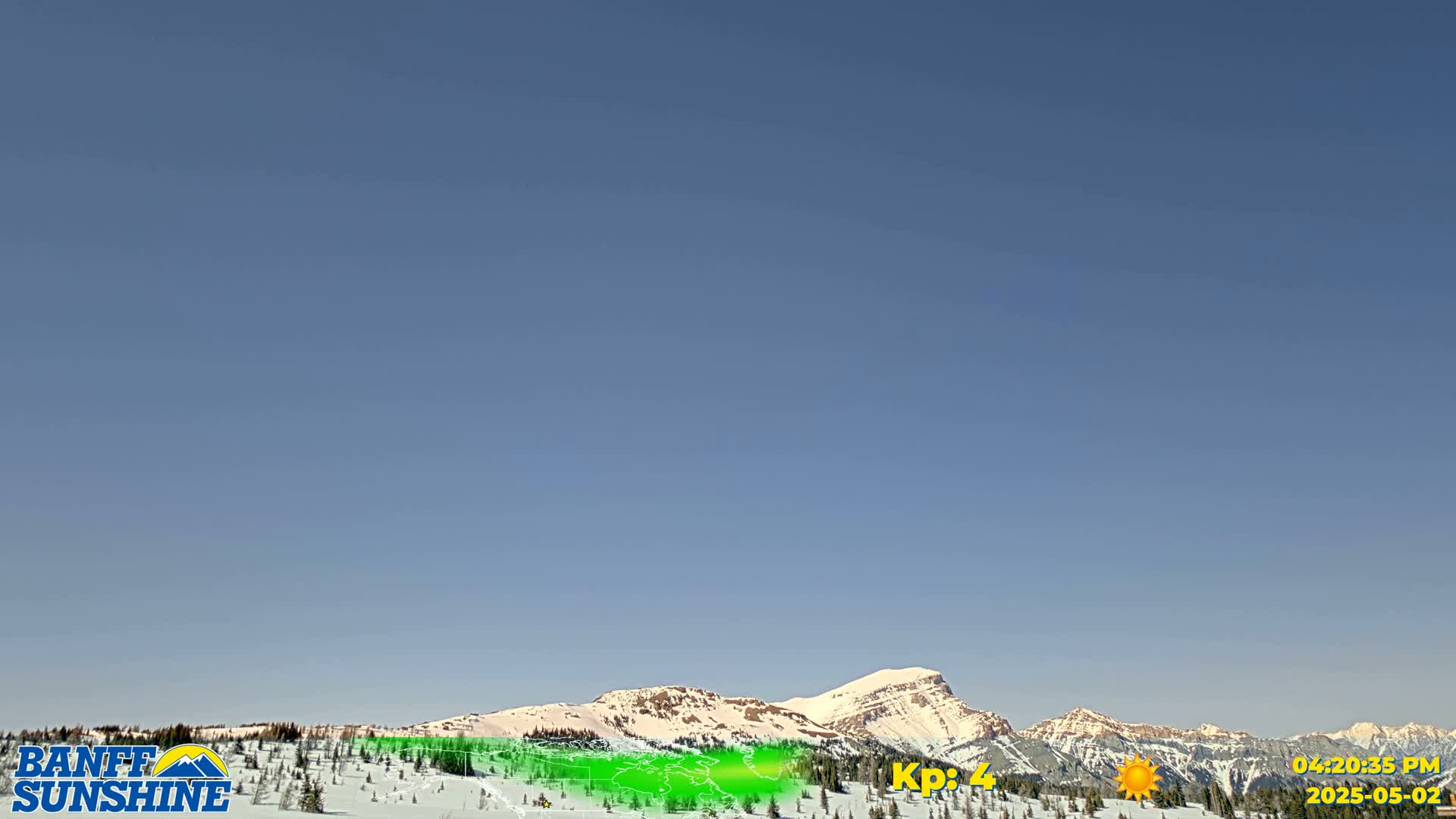 Under a clear blue sky, snow-covered mountains are visible in the distance.
