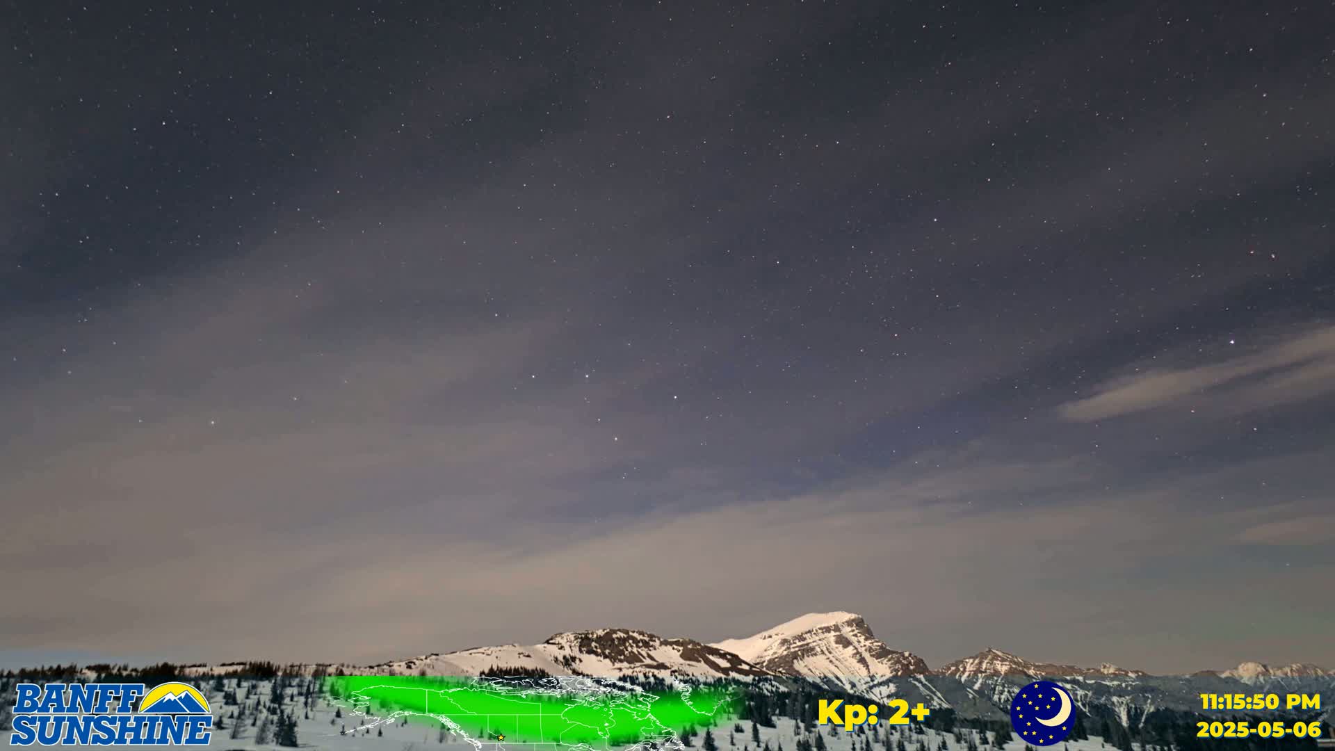 A starry night sky over snow-covered mountains.