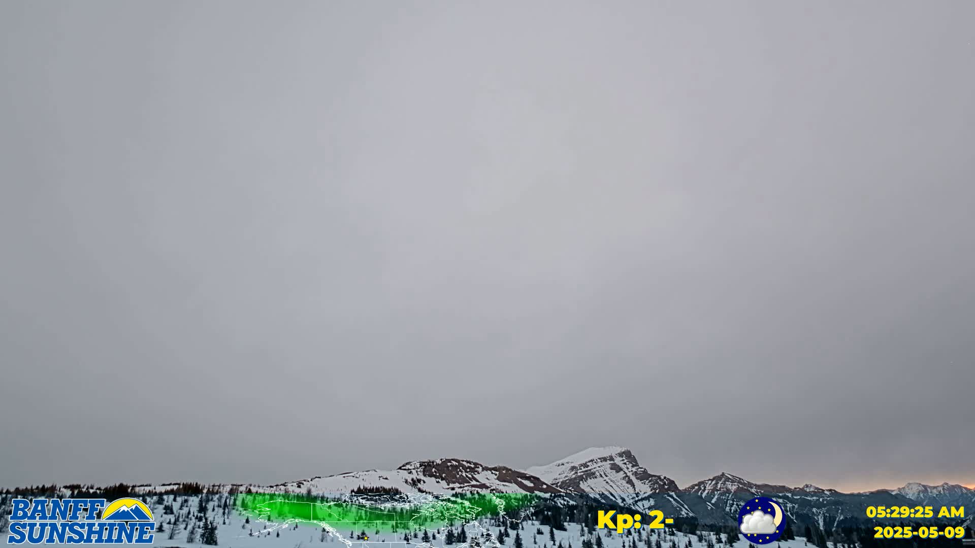 Snow-covered mountains are visible under a hazy, overcast sky.