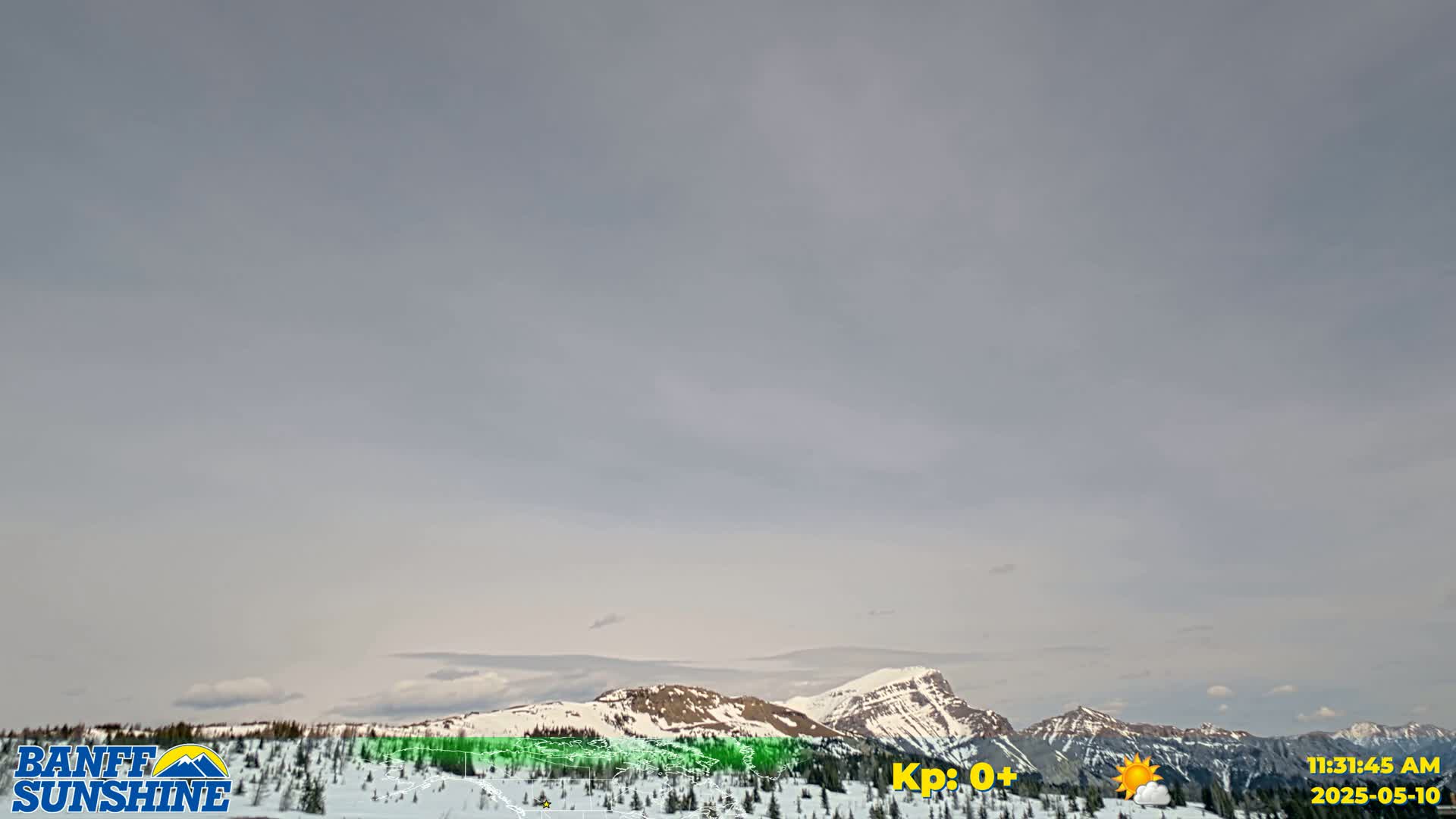 A snow-covered mountain range is visible under a mostly cloudy, light gray sky.