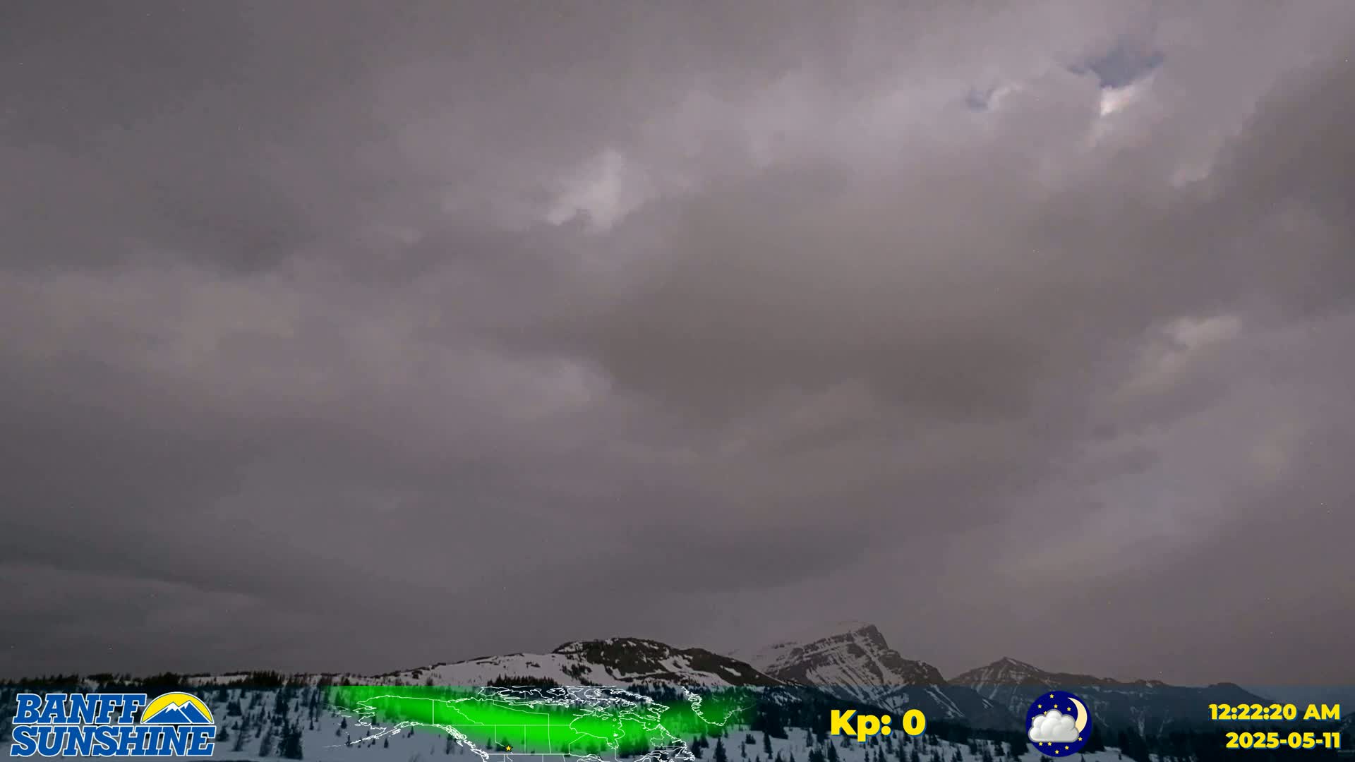 Overcast skies hang above snow-covered mountains under a dim, nighttime light.