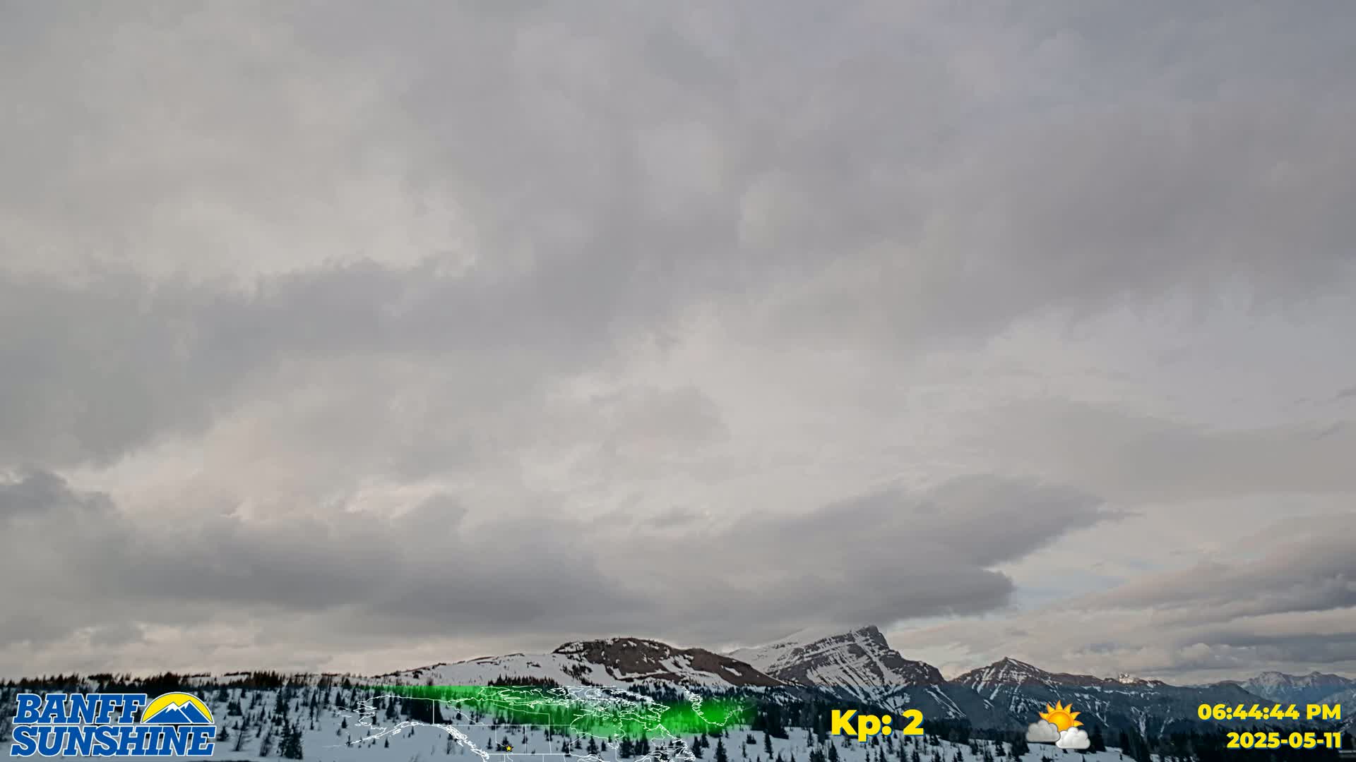 Overcast skies hang above snow-covered mountains.