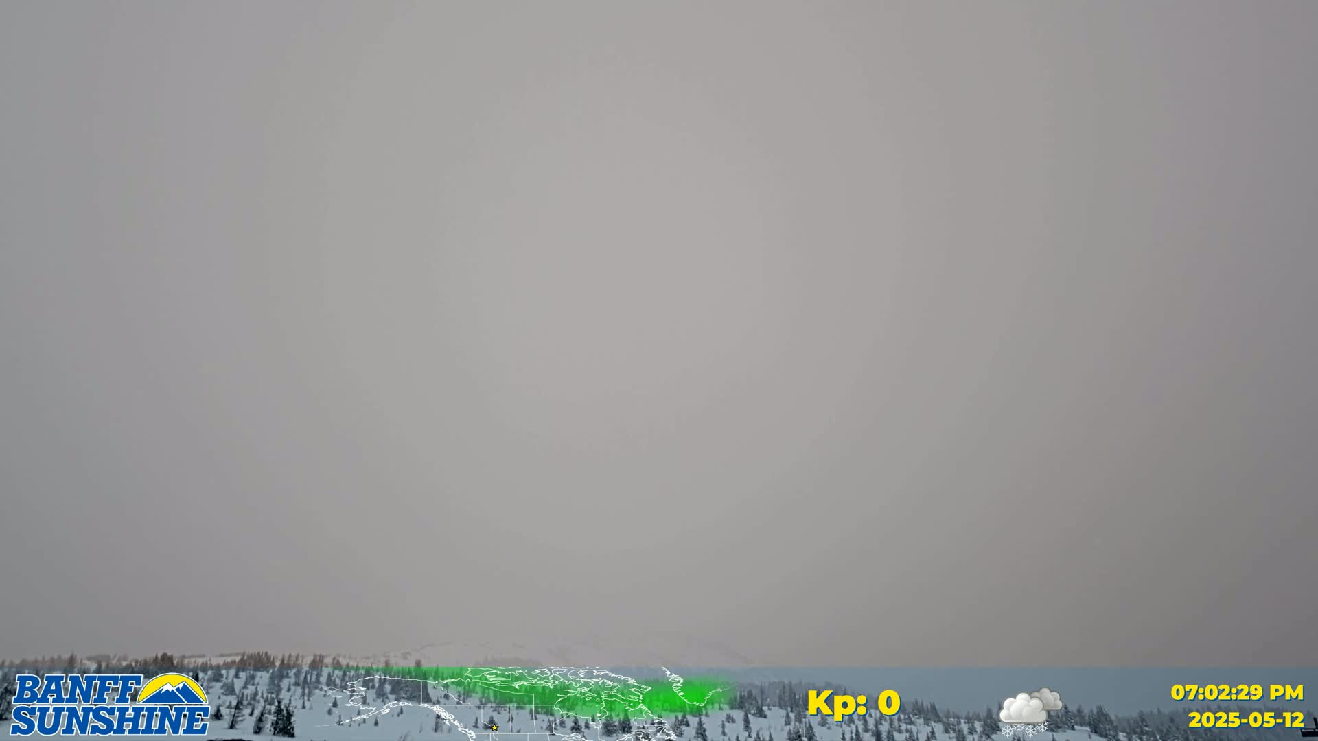A hazy, overcast sky hangs over a snow-covered landscape of coniferous trees.