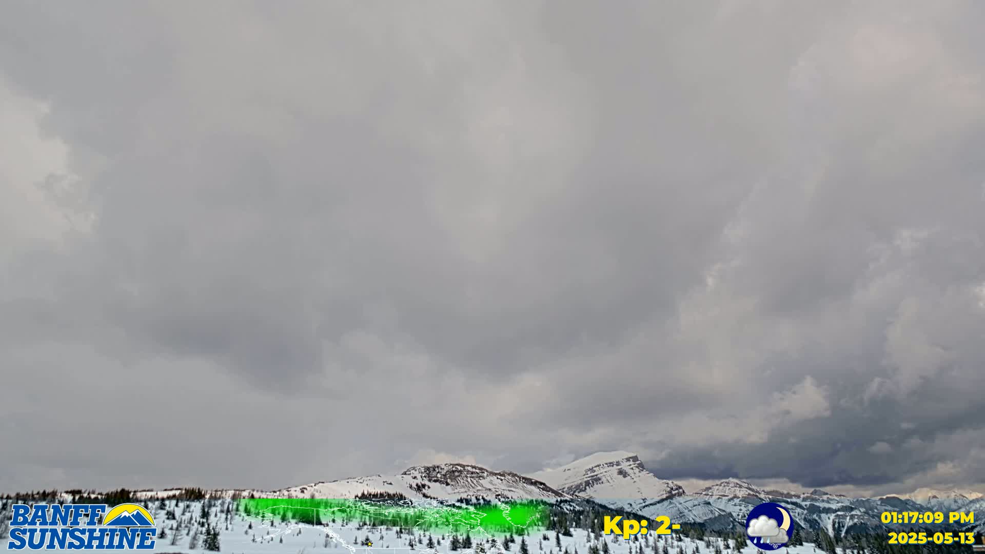 Overcast skies hang over snow-covered mountains and evergreen trees.