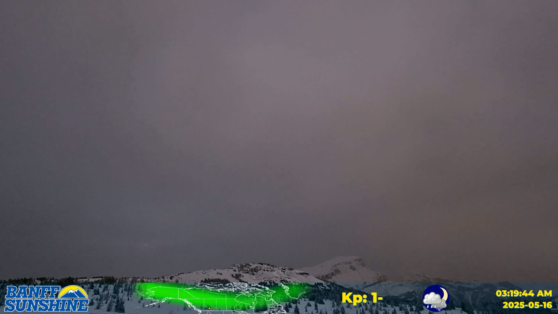 A hazy, overcast sky hangs over snow-covered mountains.
