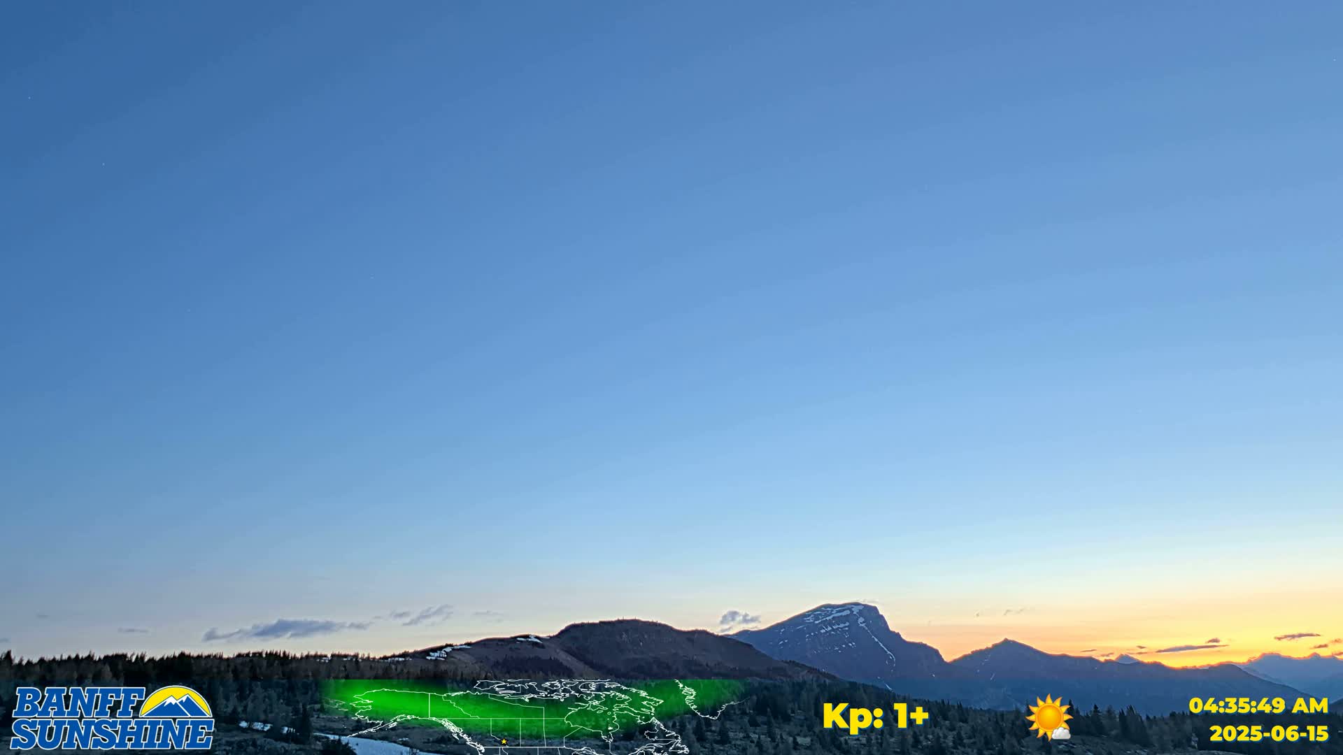 A clear, twilight sky over a mountain range at sunrise.