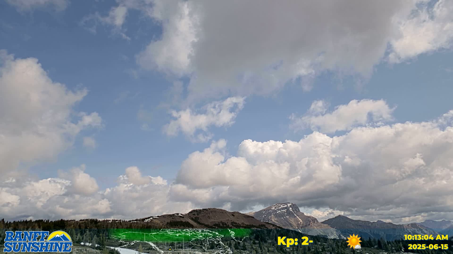 A partly cloudy sky with puffy cumulus clouds over a mountain range.