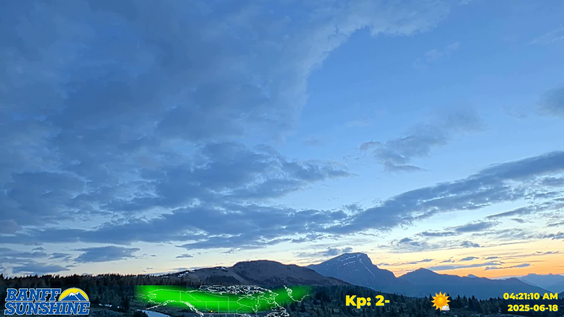 A partly cloudy sunset over a mountain range.