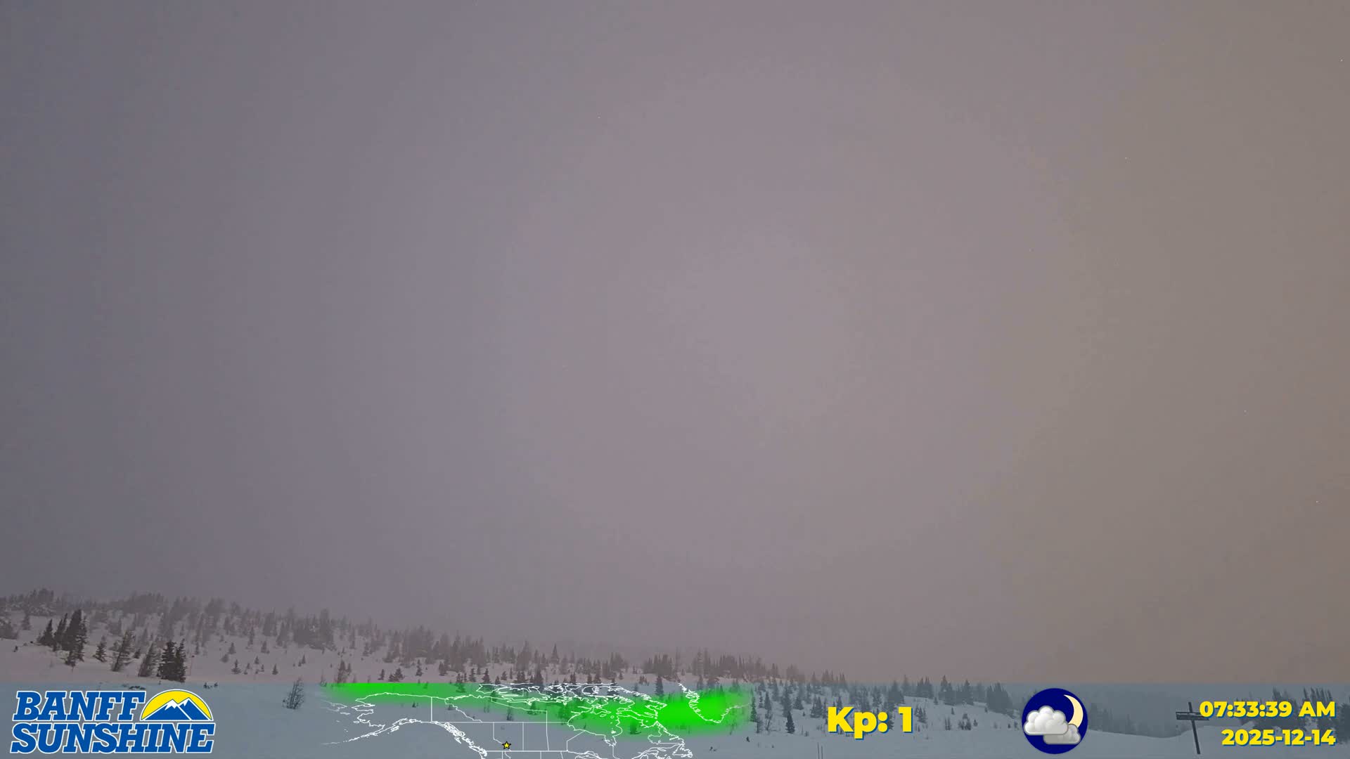 A panoramic view reveals a snow-covered mountain range with scattered evergreen trees beneath a dark, uniformly overcast sky.