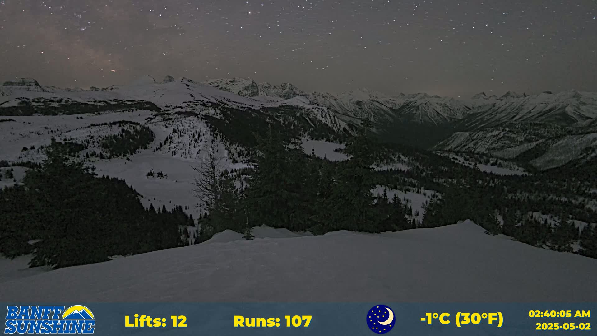 A snow-covered mountain range is visible under a starry night sky, with a temperature of 30°F (-1°C).