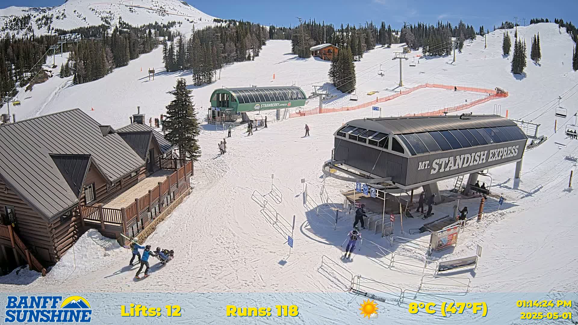 A sunny ski resort scene shows several chairlifts, a lodge, skiers, and snow-covered slopes.