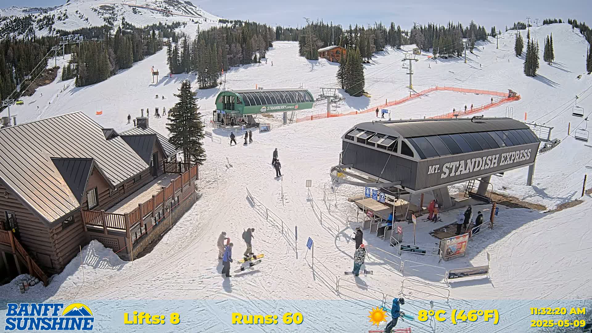 A sunny ski resort scene shows several skiers and snowboarders near chairlifts and a log cabin, with snow-covered slopes and trees in the background.