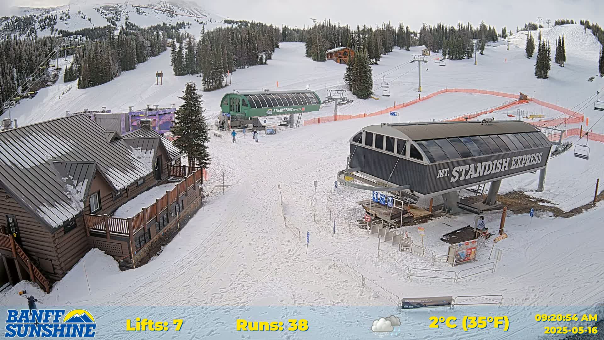 A snowy ski resort with two chairlifts, a lodge, and several ski runs under overcast skies.