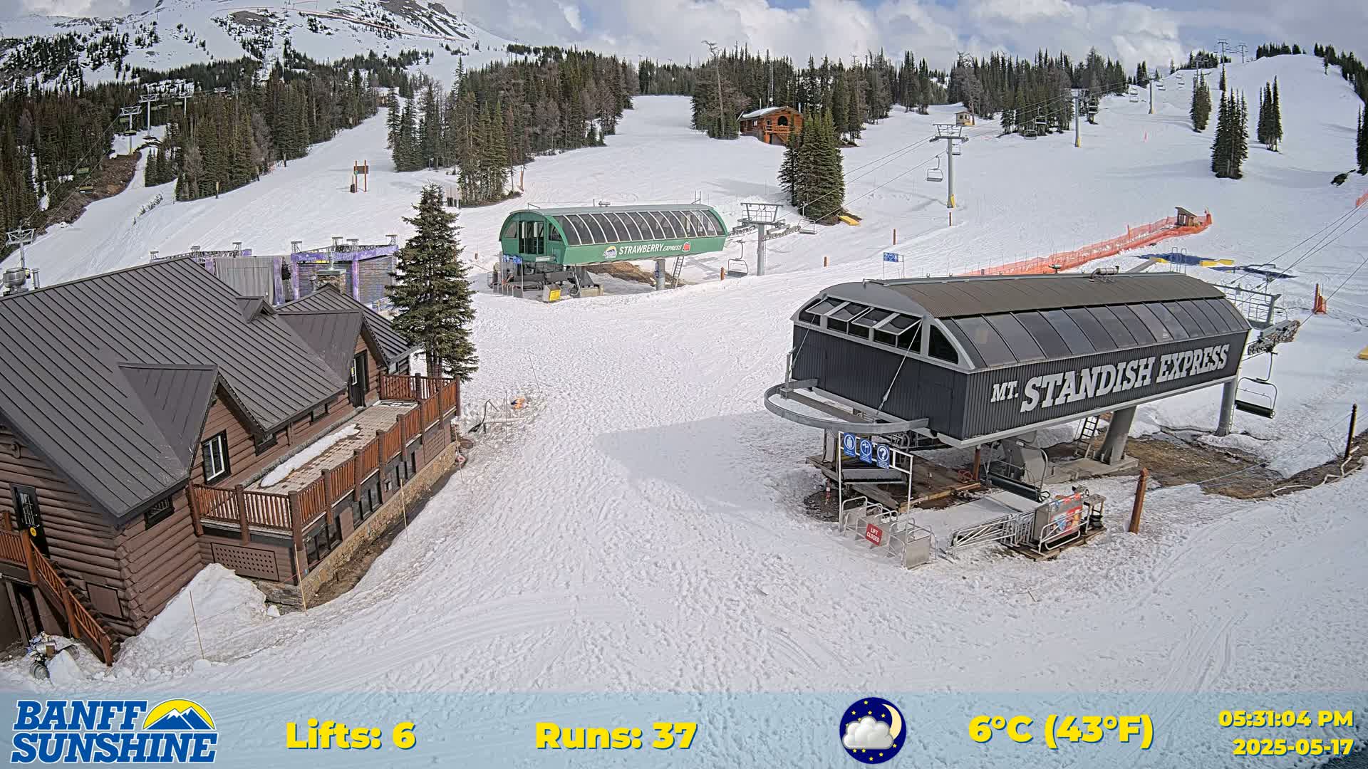 A ski resort scene shows two chairlifts, a lodge, and snow-covered slopes under partly cloudy skies, with a temperature of 6°C (43°F).