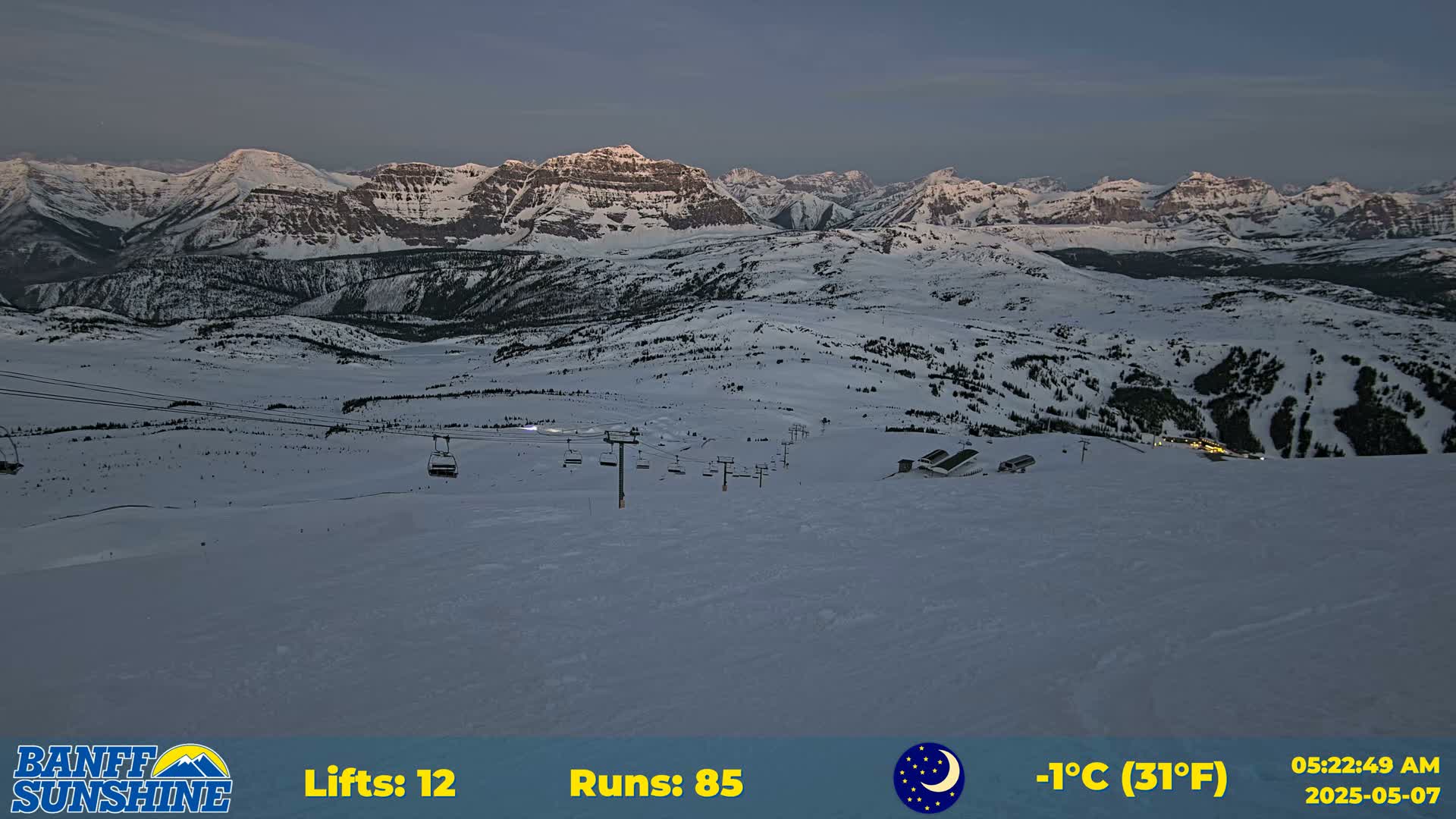 A snow-covered mountain landscape at dusk, showing ski lifts and runs, with a temperature of -1°C (31°F).