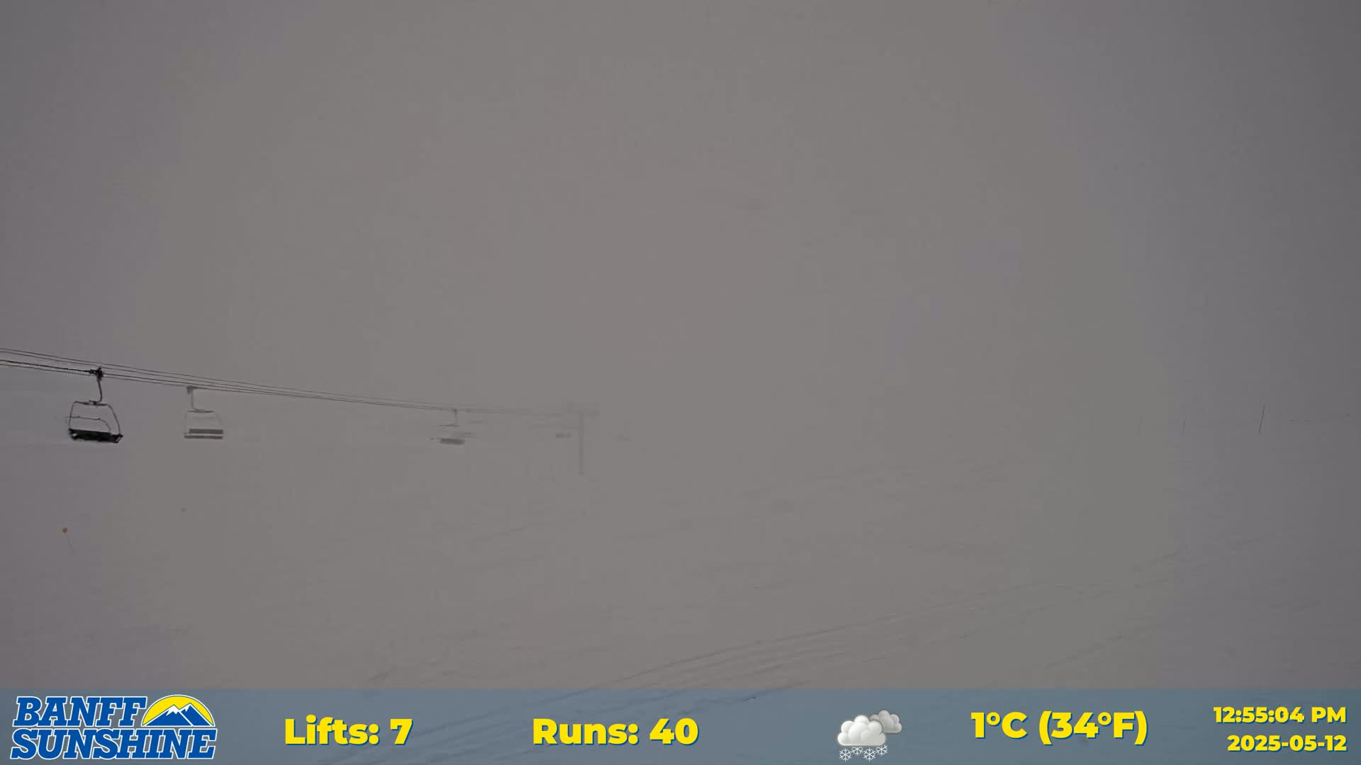 A snowy, foggy ski resort with several chairlifts visible.