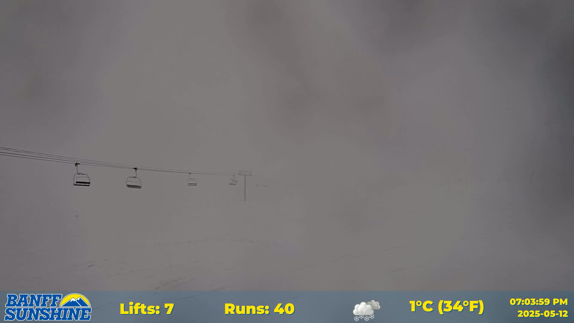 A snowy landscape is barely visible through heavy fog, with several empty chairlifts in the foreground.