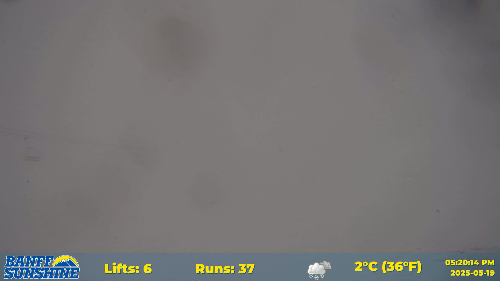 A mostly overcast sky with light snow is visible.