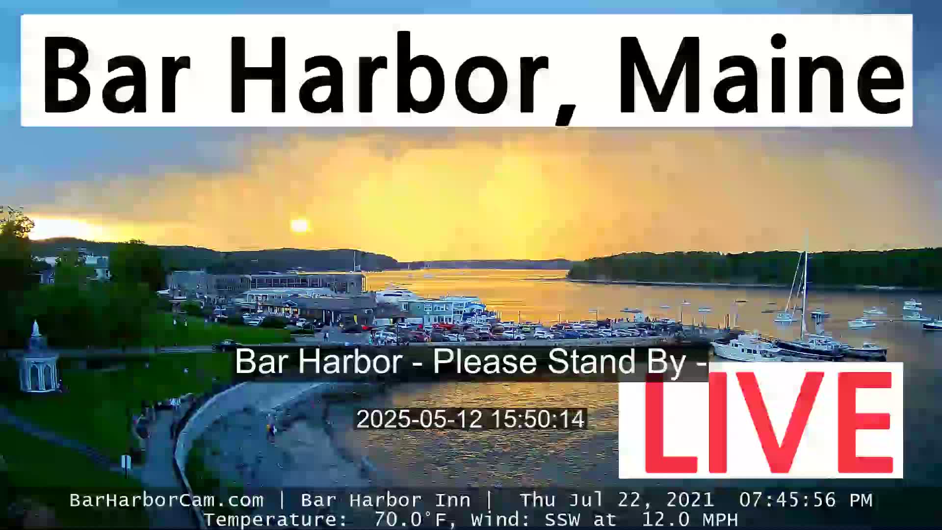A sunset over a harbor filled with boats, under a partly cloudy sky.