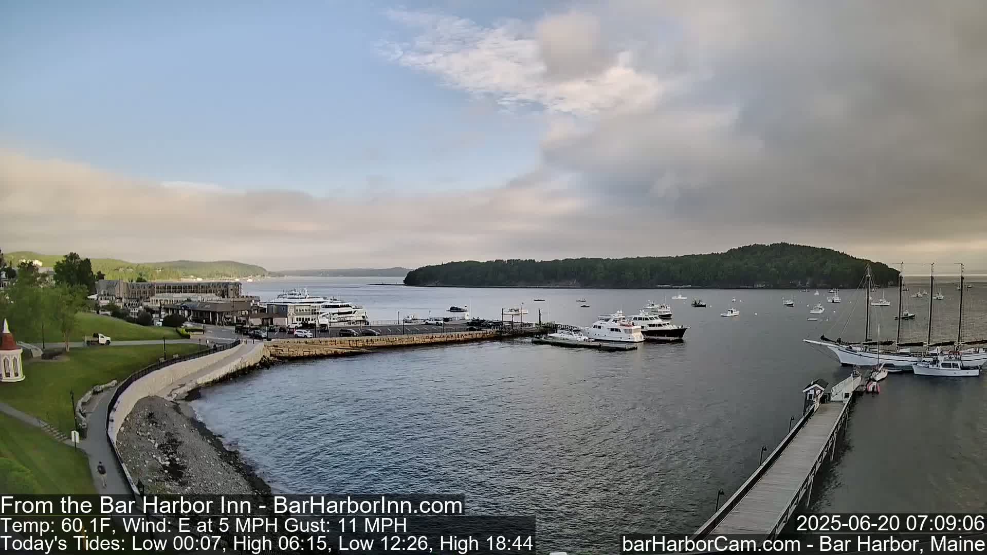 A harbor filled with numerous boats and ships under a partly cloudy sky.