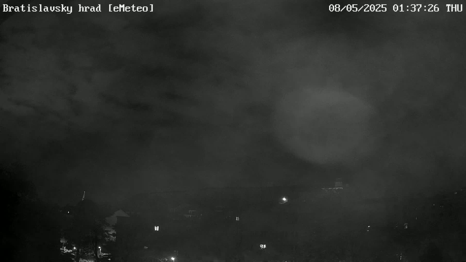 A nighttime view of a town under a dark, cloudy sky.