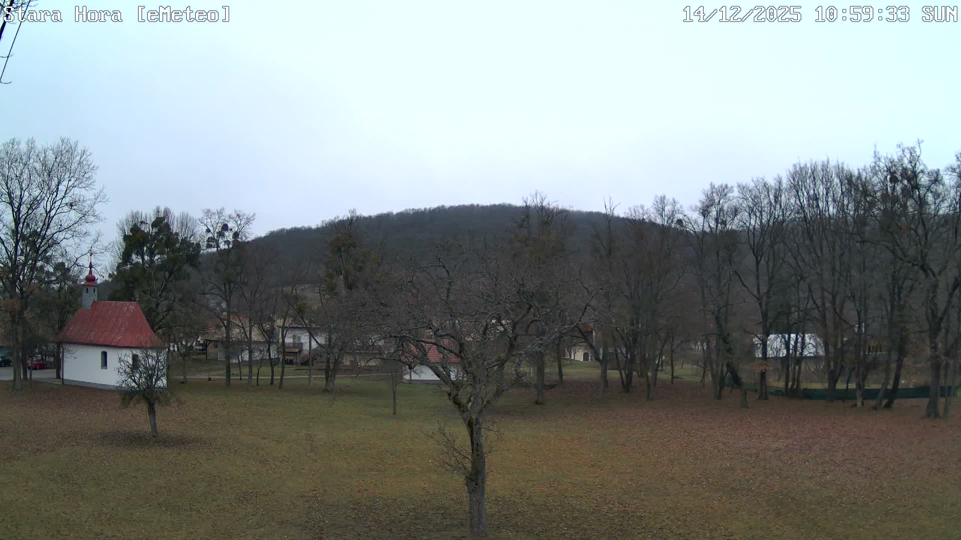 An extremely dark outdoor night scene shows only faint, indistinct shapes against a black background, indicating clear but unlit conditions.