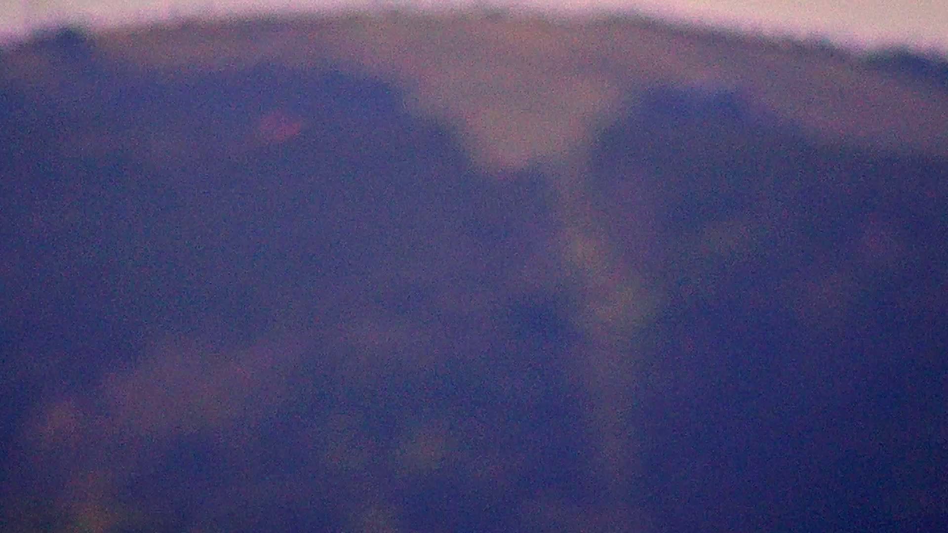 A blurry, out-of-focus image shows a hazy, purple-toned landscape of distant hills.