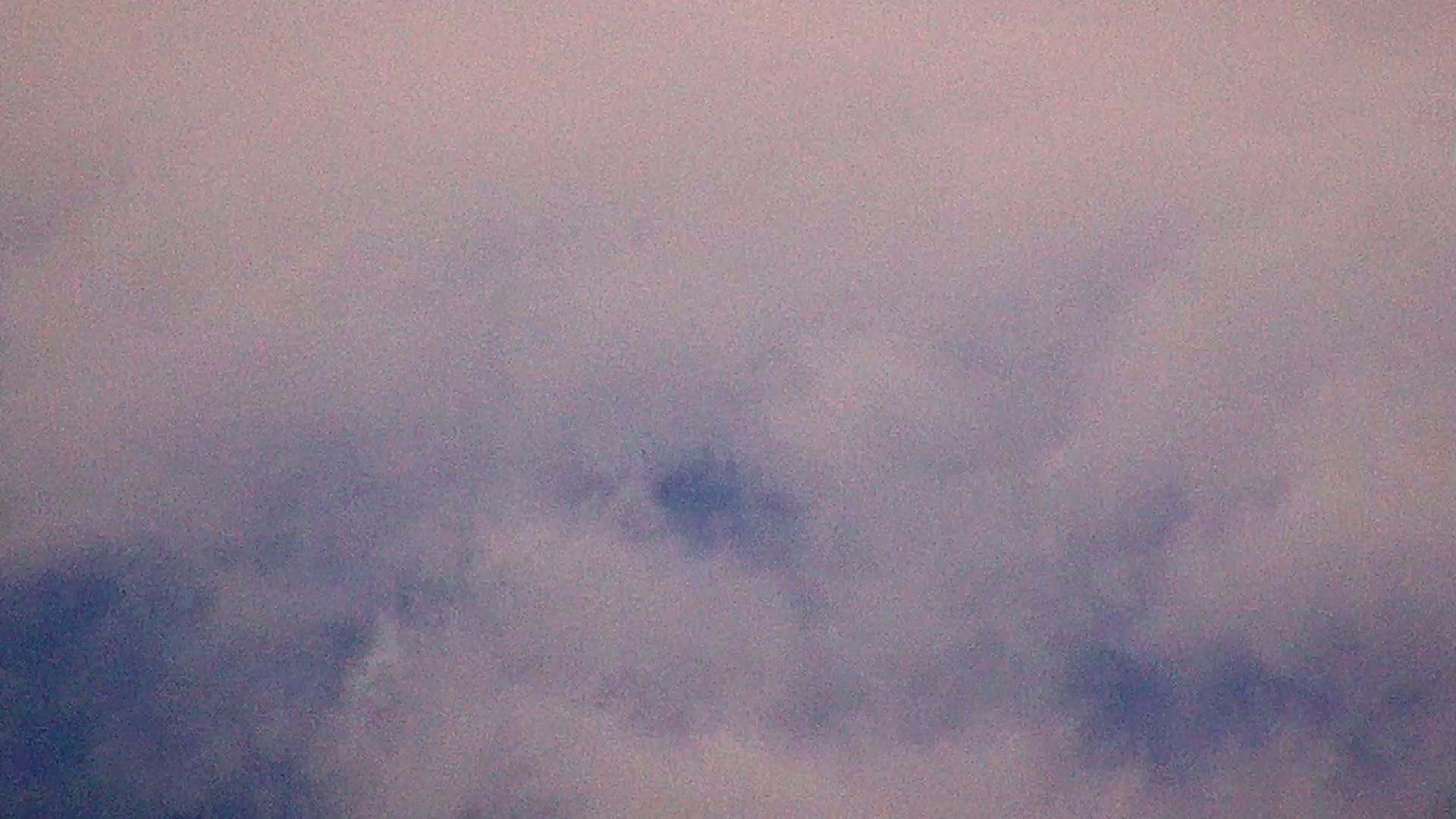 A mostly cloudy sky, with muted purple and gray hues.