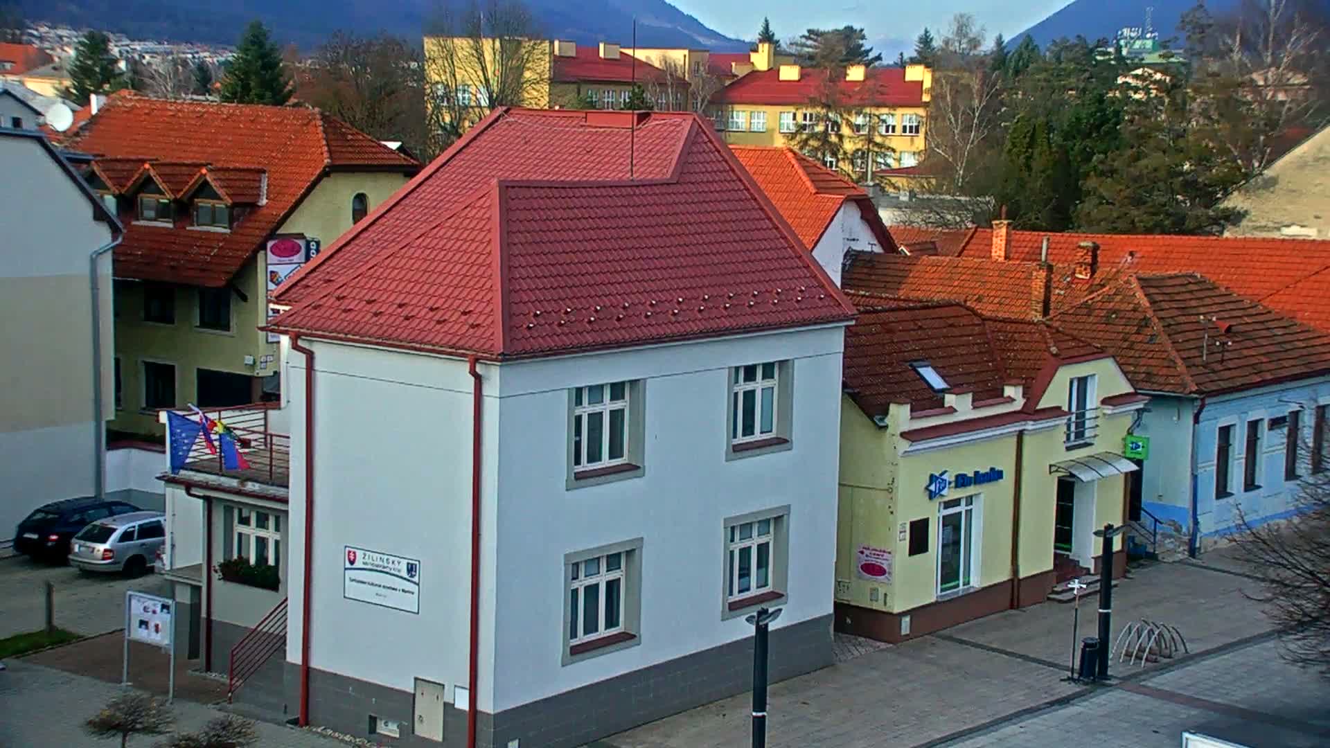 A dark outdoor scene at night shows rows of streetlights illuminating pathways and a brightly lit building in the distance under clear skies.