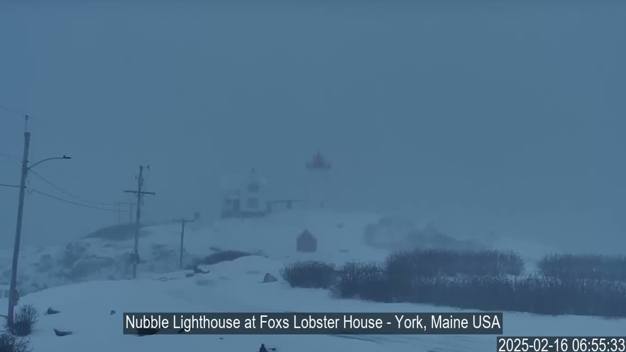 A snow-covered landscape with a lighthouse partially obscured by blowing snow is visible in the distance.