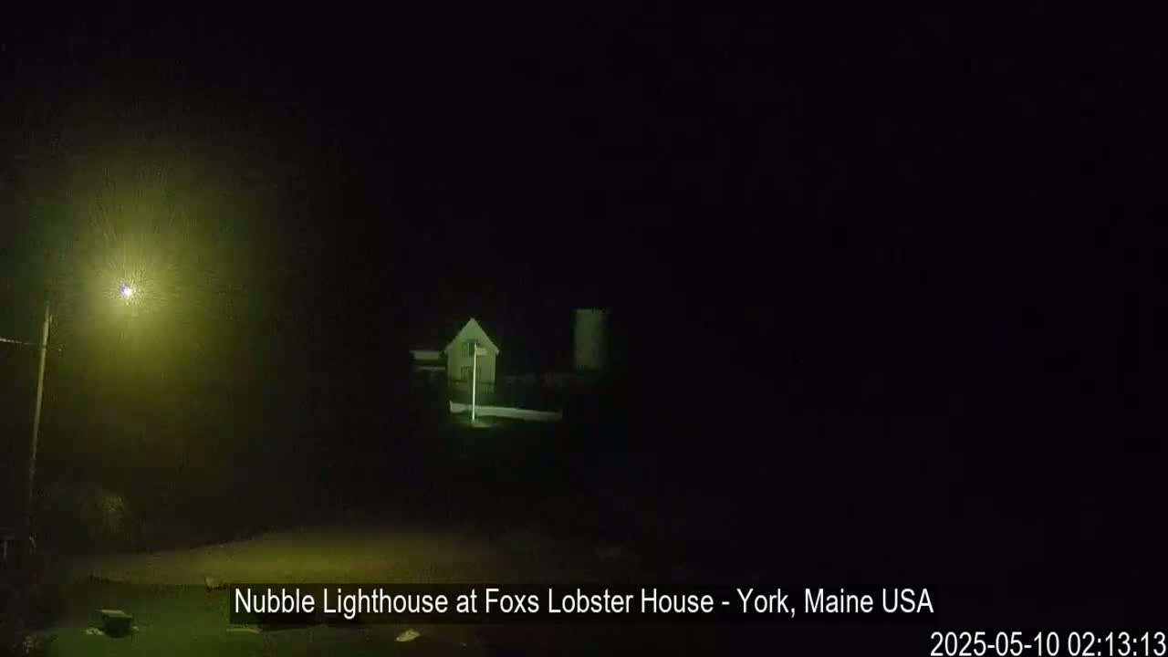 A dimly lit building is visible in the dark, under foggy nighttime conditions.