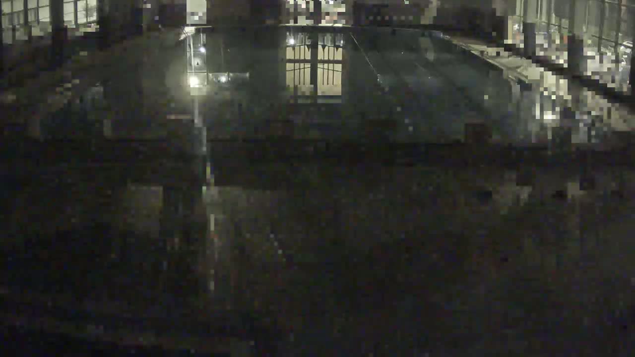 An indoor swimming pool is visible at night, appearing dark and mostly empty.