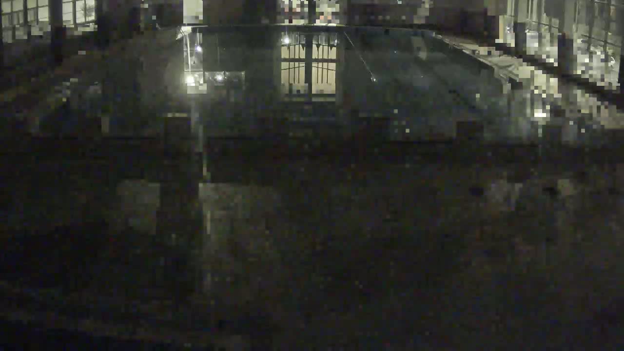 A dark, nighttime view of a partially visible indoor pool, seen from above.