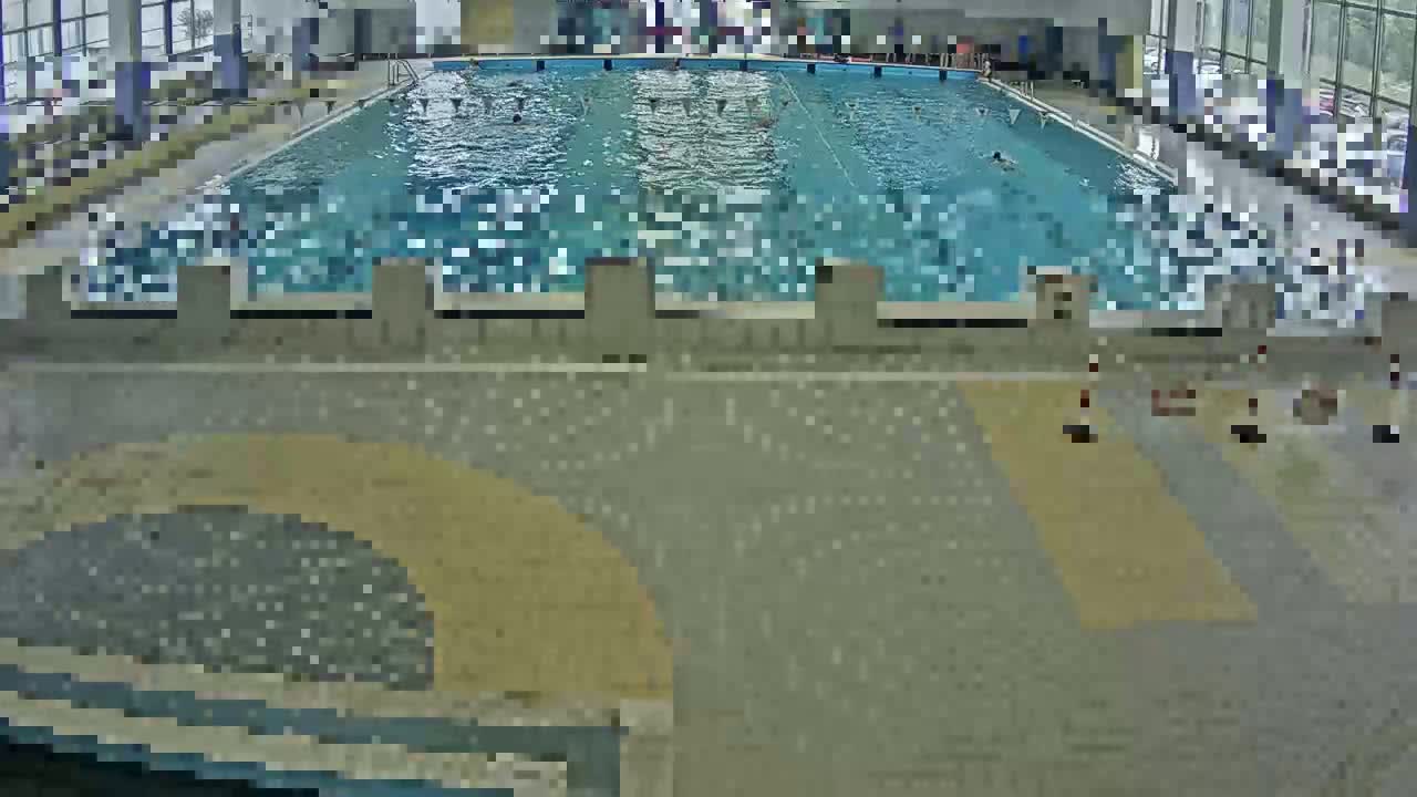 An indoor swimming pool with many people swimming in it.