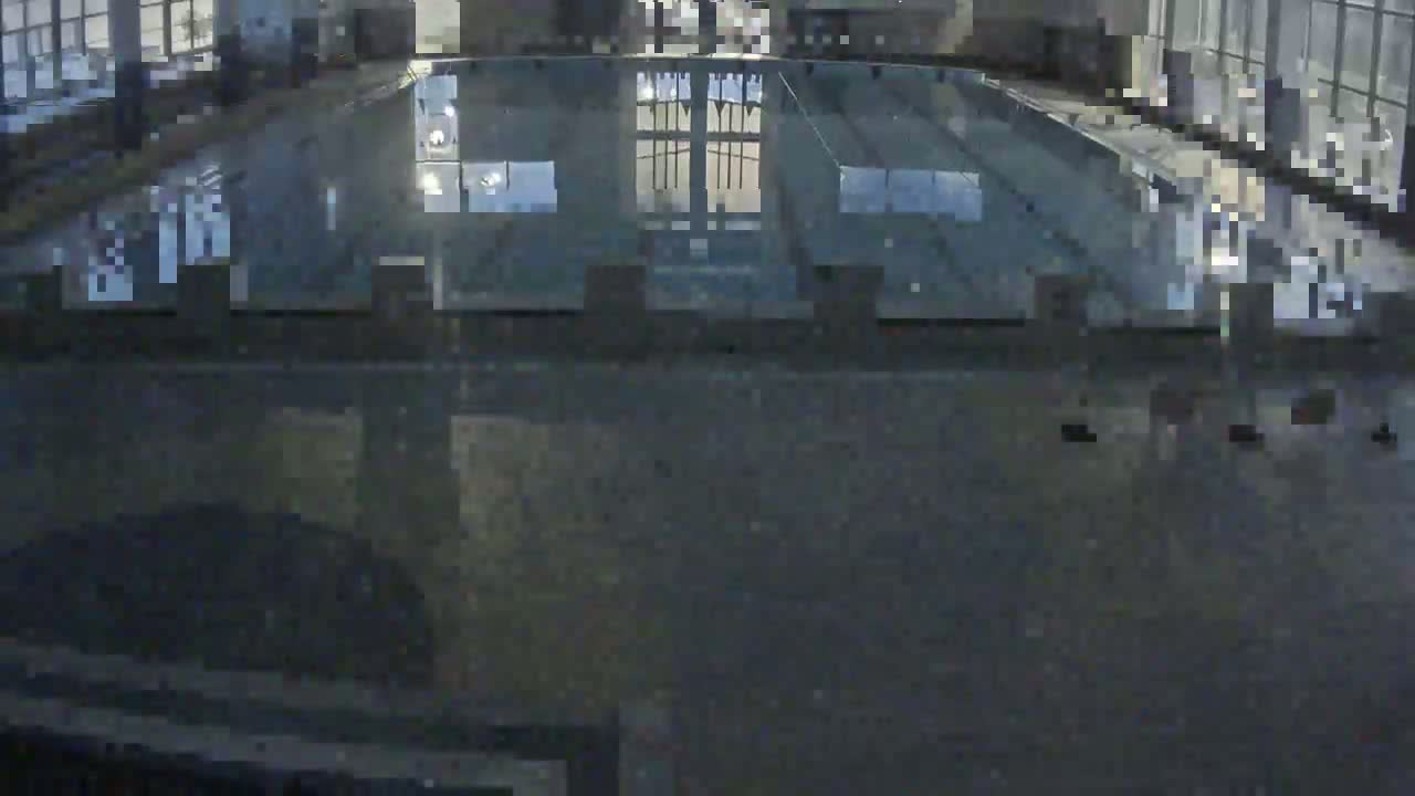A dark, indoor view of a glass-covered area, possibly a pool or skylight, reflecting a dark exterior.