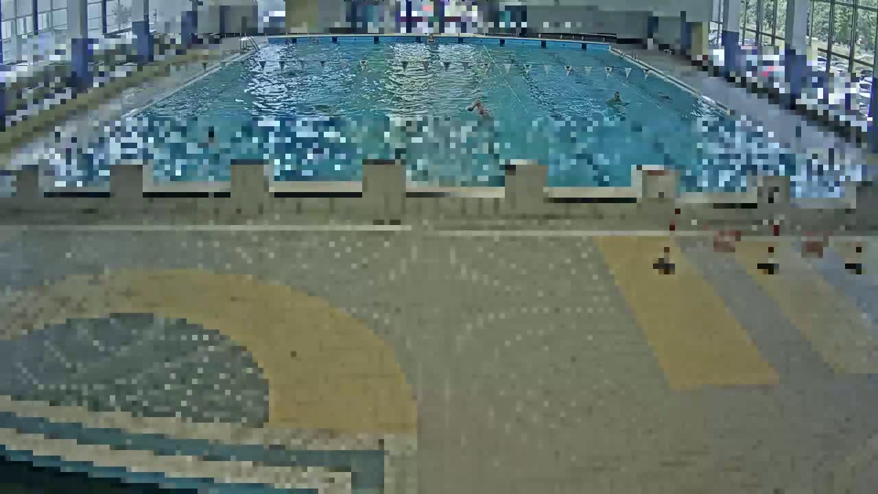 An indoor swimming pool with several people swimming in it.