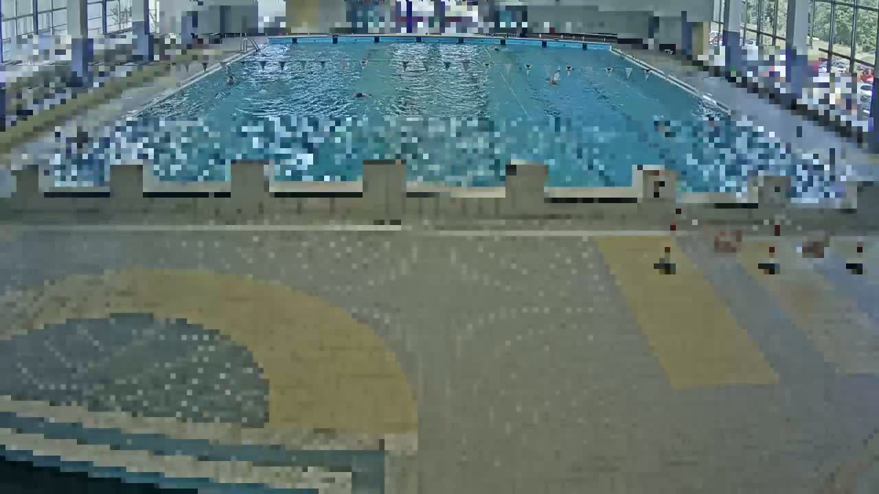An indoor swimming pool with several people swimming in it.