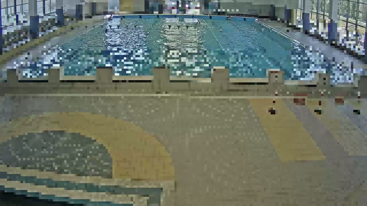 An indoor swimming pool with several people swimming in it.